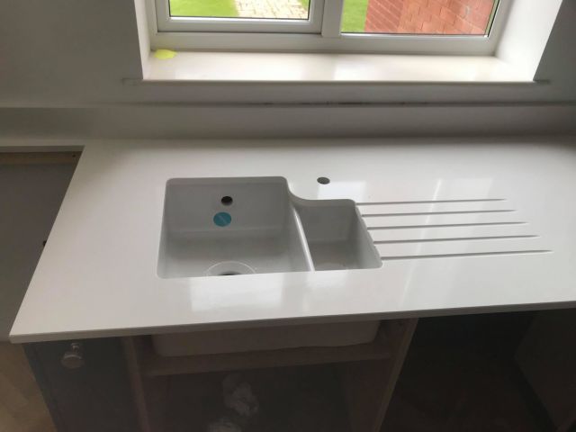 Curved sink cutout and custom drainer grooves
