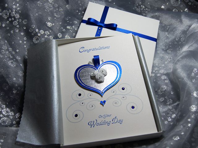 Cinderella is a luxury handmade wedding card for those fairytale weddings, with a touch of magic. This design uses Deep Blue and Silver with a hint of White creating an elegant and regal feel. This luxury card details a heart shaped carriage with three wh